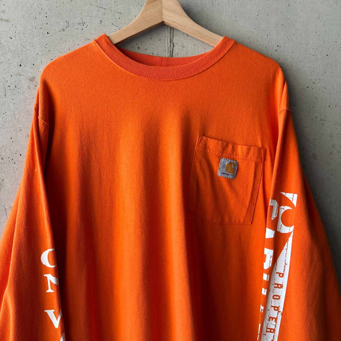 (L) Reme Carhartt Pocket Manga Larga Naranja "Property Of Carhartt"